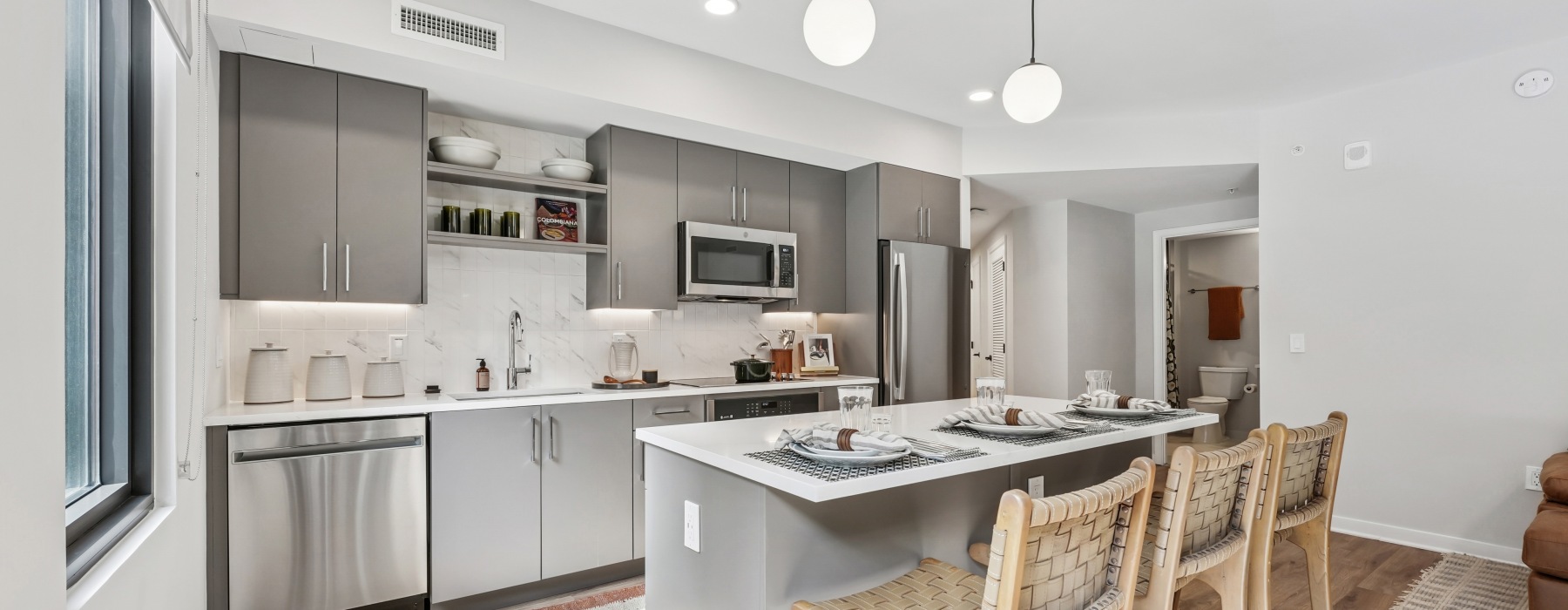 Kitchen with island, barstools, and grey cabinetry