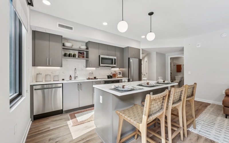 kitchen with island, barstools, white countertops and backsplash