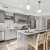 kitchen with island, barstools, white countertops and backsplash