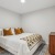 Bedroom with queen sized bed, dresser, and night stand