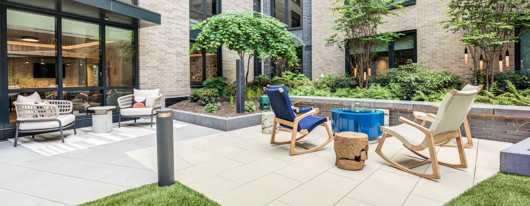 a patio with chairs and a table outside a building